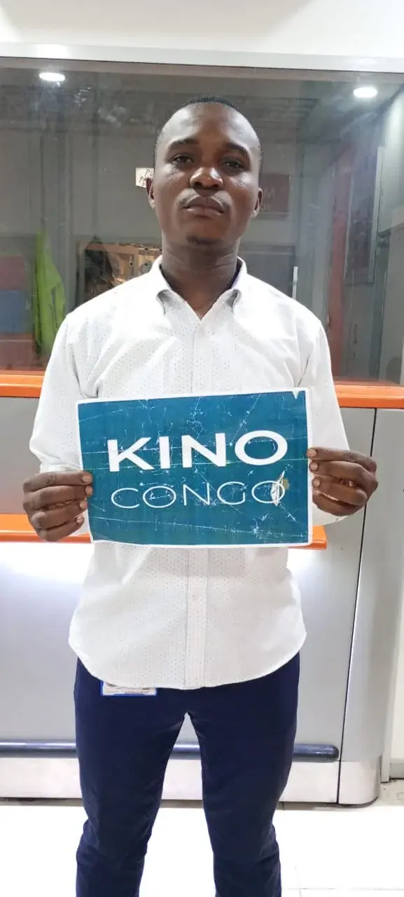 Agent Kino Congo à l'aéroport avec panneau nominatif